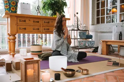 Ana en meditación con cuencos tibetanos y velas